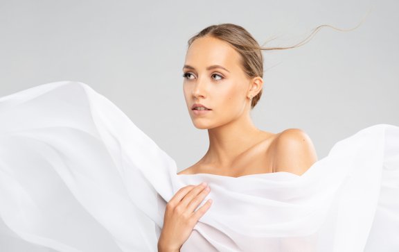 Plastic surgery patient behind a white sheet