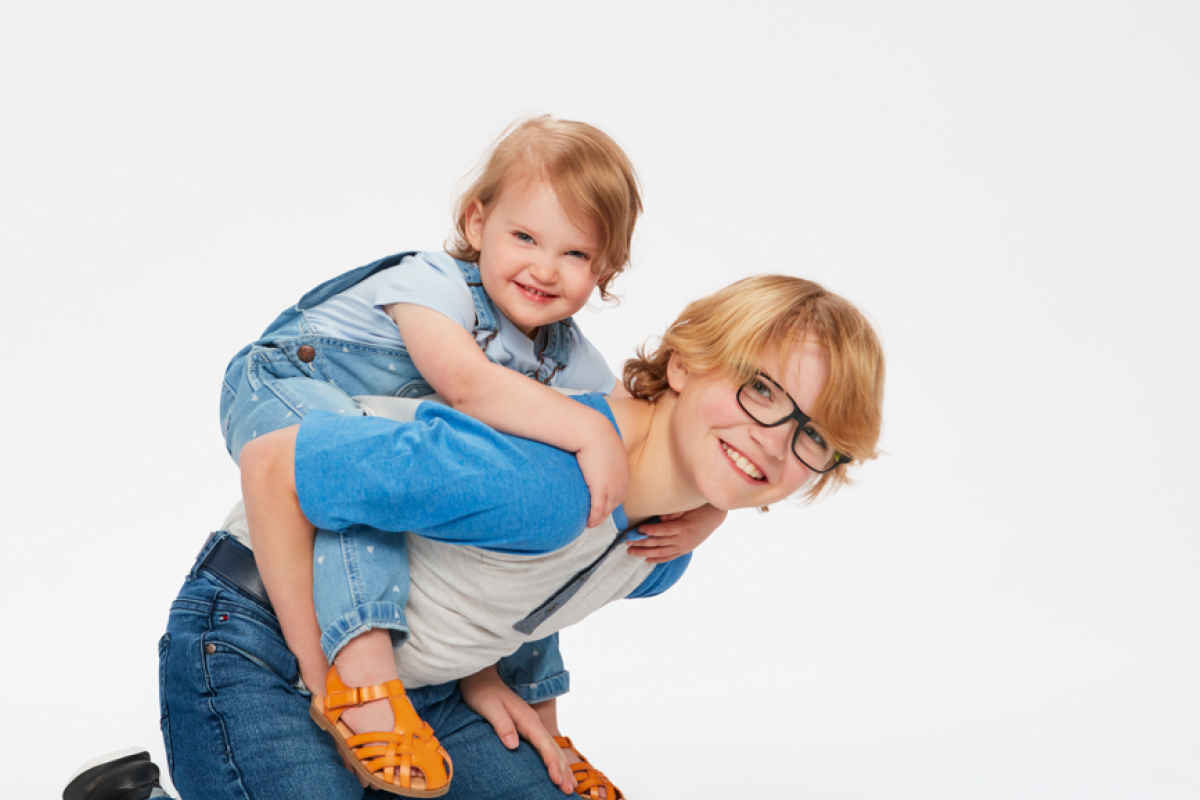 Brother holding baby sister on back