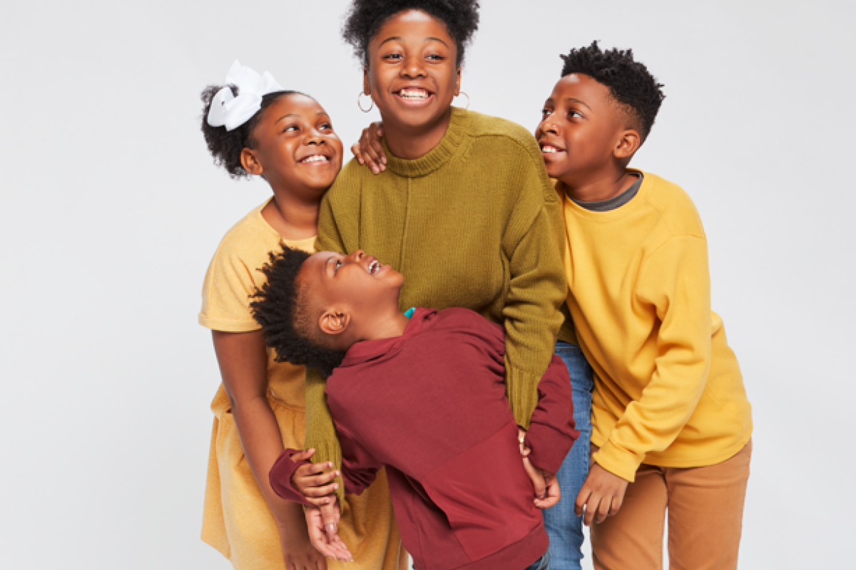Family of four siblings hugging and laughing