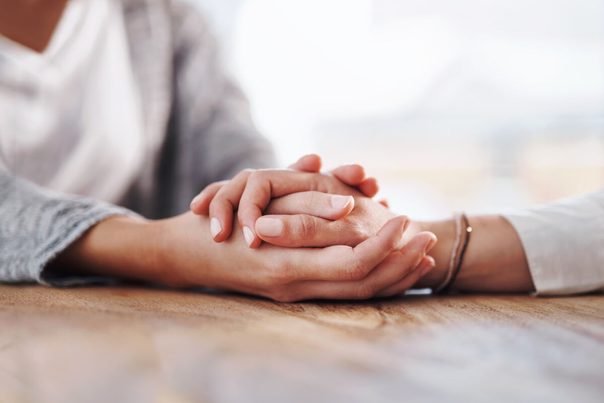 Two people holding hands on table