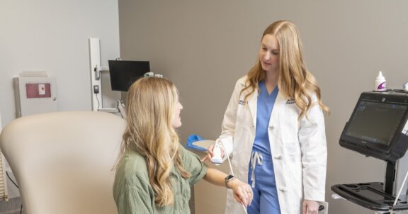Doctor performing ultrasound on patients arm
