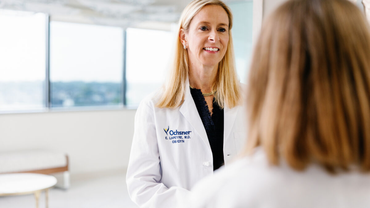 Dr. Lapeyre in a white coat talking with another physician