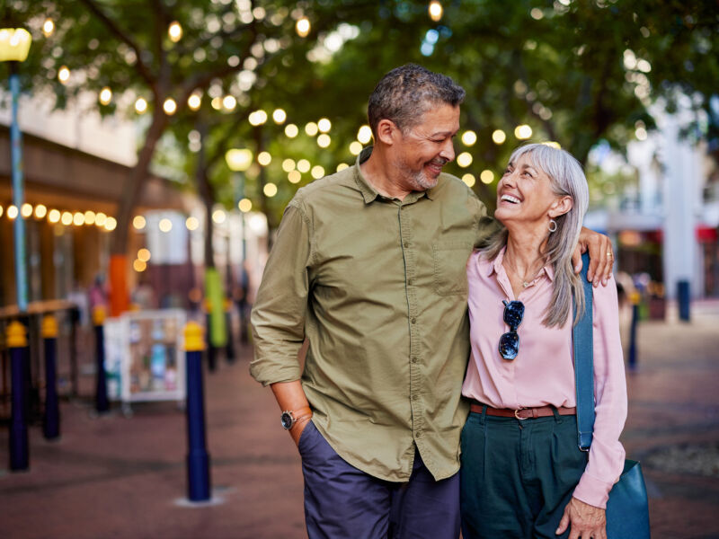 Husband and wife strolling outside and smiling