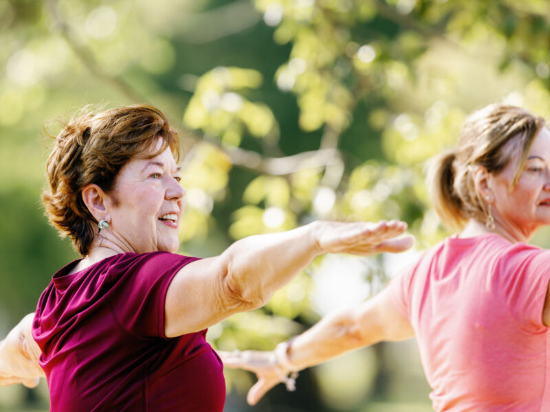 Neuroscience patient Diane and Alicia stretching outside