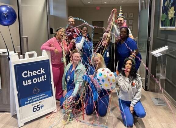 Group of people celebrating in Pensacola clinic lobby