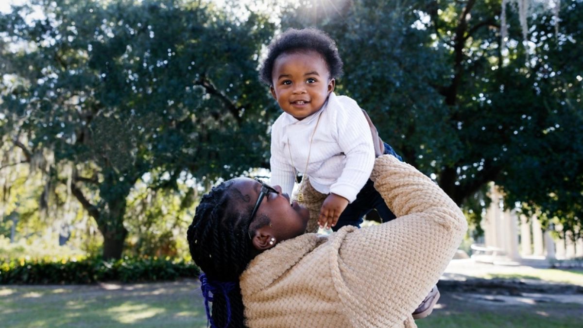 Mother holding son in the air and laughing