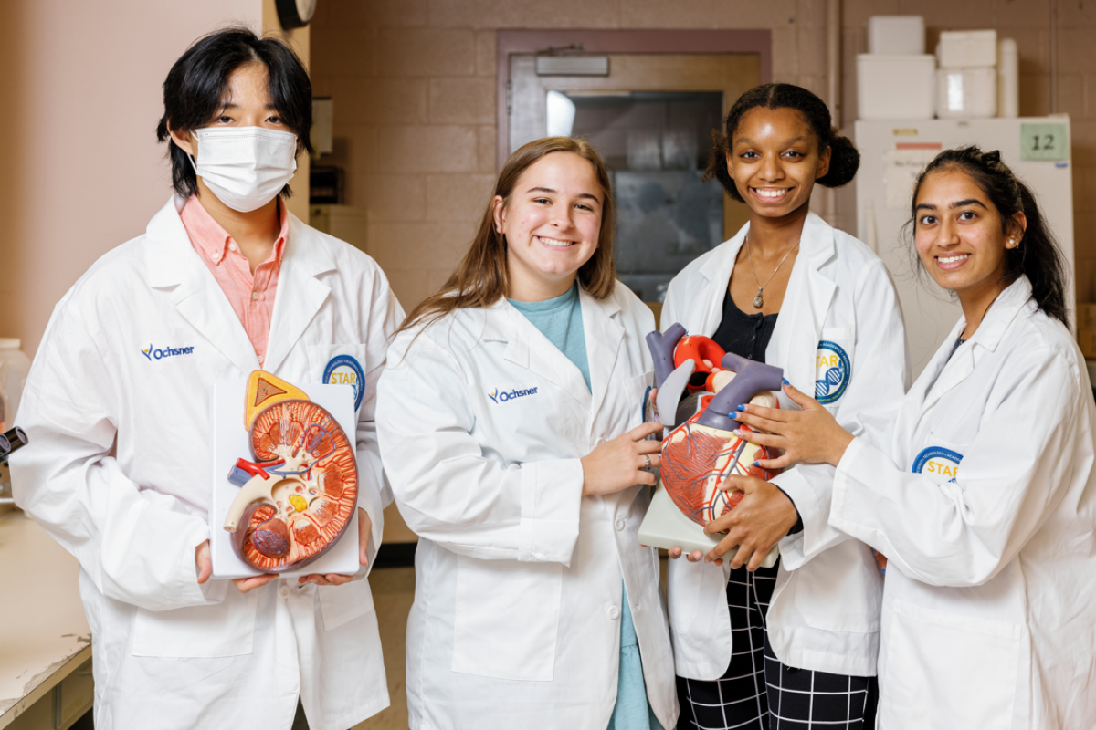 Students in white lab coats smiling