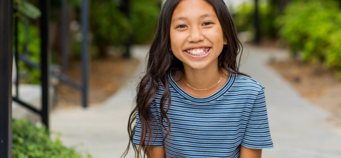 Girl smiling at the camera while standing outside