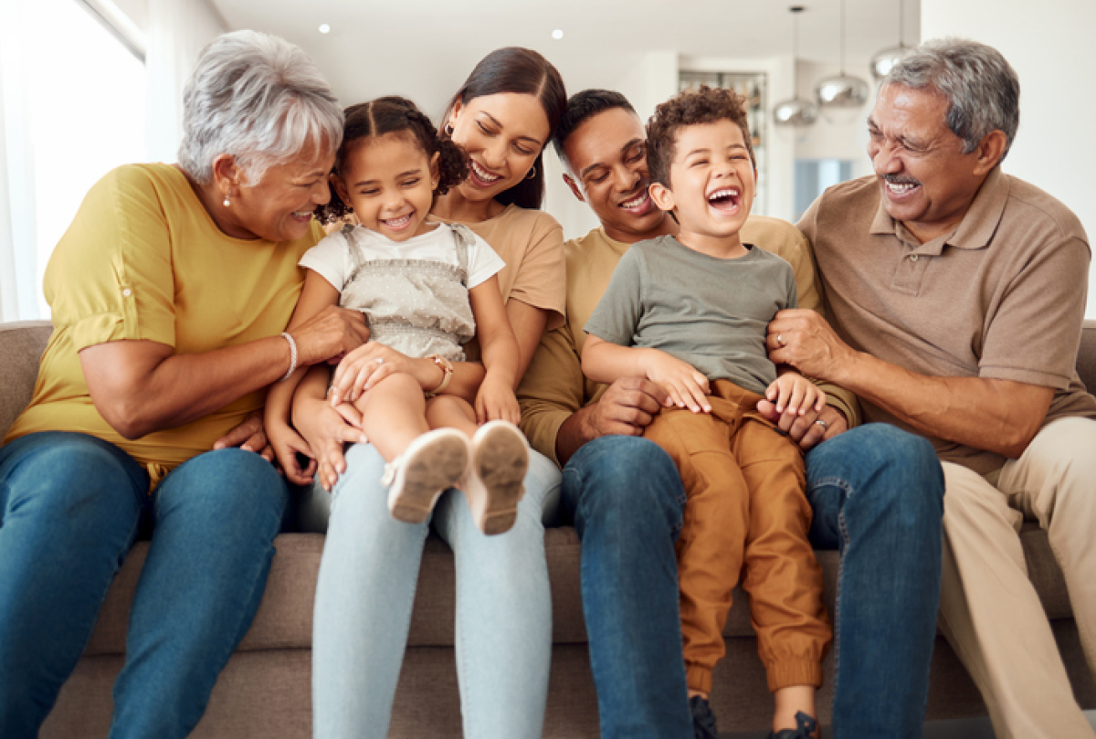 Three generations of family sitting and laughing