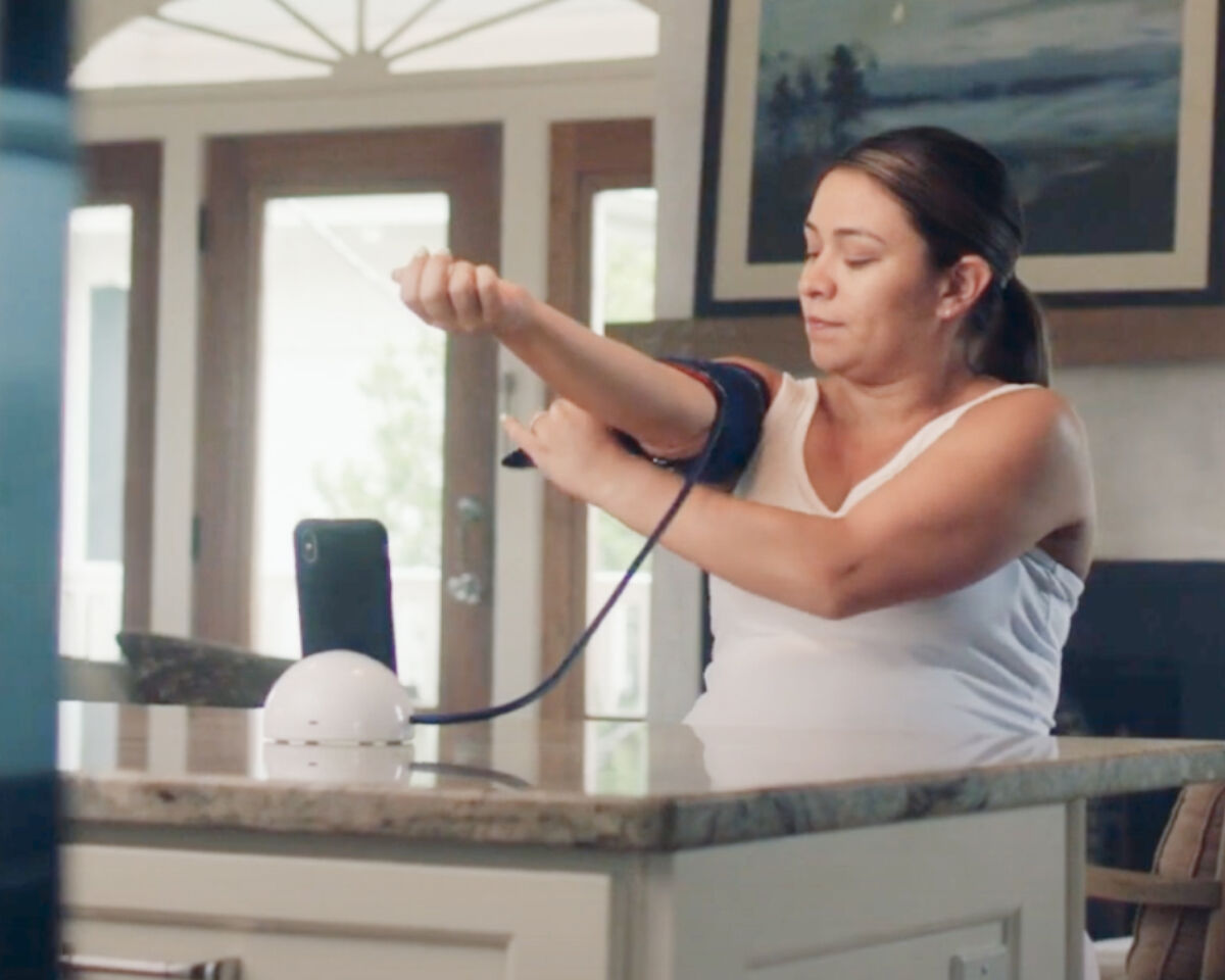 Woman taking blood pressure at home with Ochsner Connect Health program