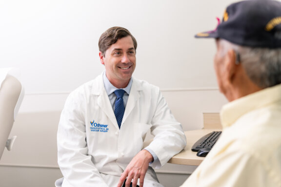 Vascular surgeon talking with patient in waiting room.