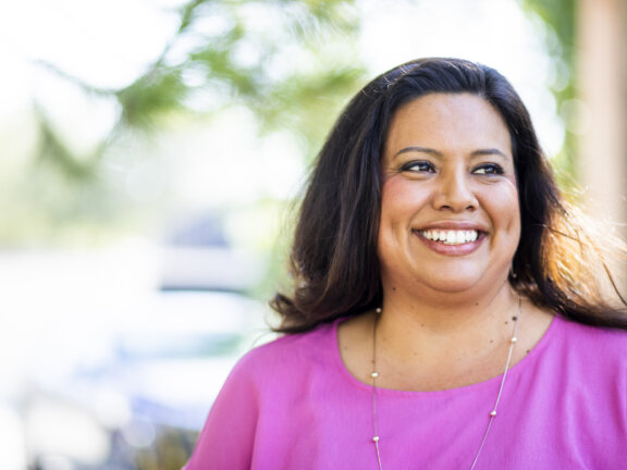 woman smiling while standing outside