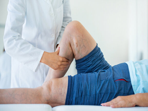 Ochsner vascular and endovascular patient lying on exam table being examined by doctor.
