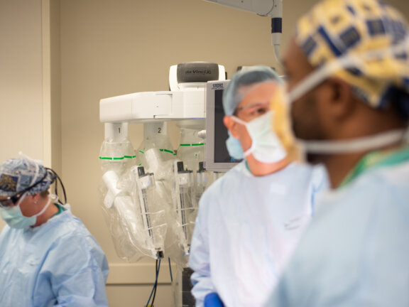 Doctors in operating room performing robotic surgery