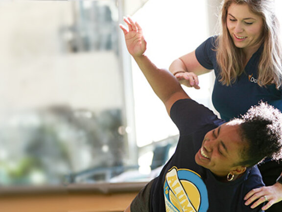 Woman stretching with physical therapist