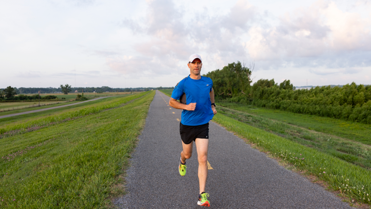 Male cardiology patient running on top of the levee