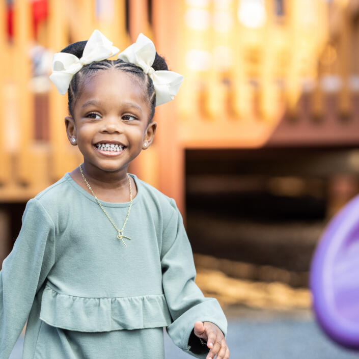 A girl smiles on the playground