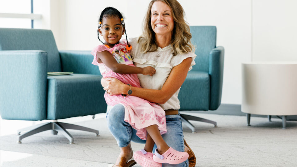 Pediatric living liver transplant recipient sitting on the lab of her living liver donor.