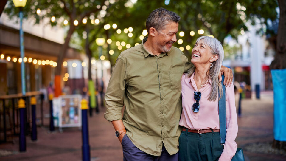 Husband and wife strolling outside and smiling