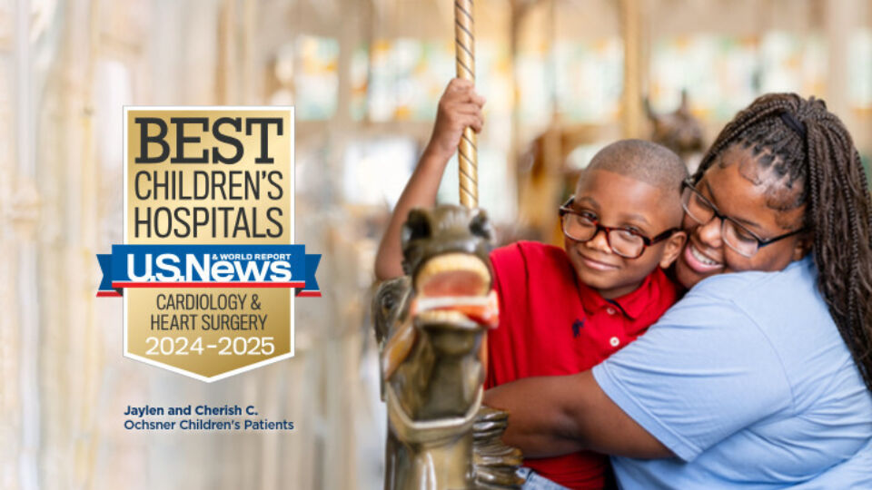 two kids smiling and hugging while riding a carousel