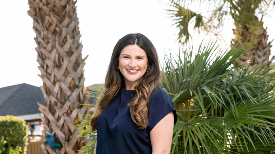woman in blue shirt smiling outside