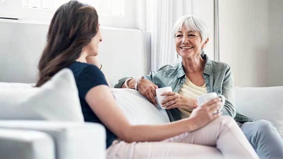 Two women talking while sitting on a couch